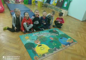 Grupa chłopców z grupy Małpki prezentuje swój obrazek z puzzli - kosze do segregacji śmieci.